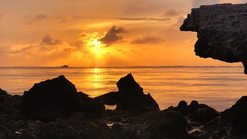 Scenic view of sea against orange sky