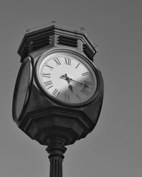 Low angle view of clock against the sky