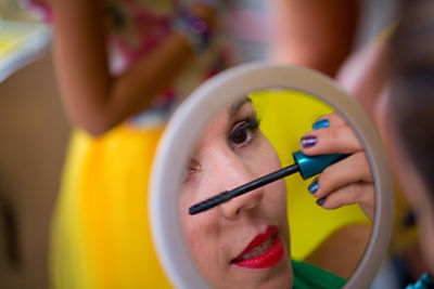 Close-up of young woman applying mascara