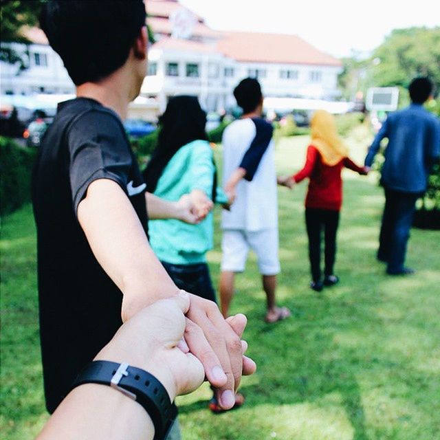 lifestyles, men, leisure activity, togetherness, large group of people, person, focus on foreground, bonding, love, holding, friendship, grass, city, medium group of people, building exterior, day, outdoors, city life