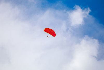 Low angle view of person paragliding against sky