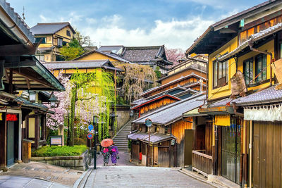 Street amidst buildings in town against sky