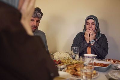 Family praying before eating dinner