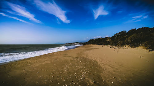 Scenic view of beach against blue sky