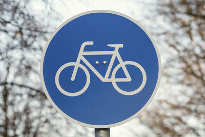 Low angle view of road sign against blue sky