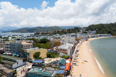 High angle view of townscape by sea against sky