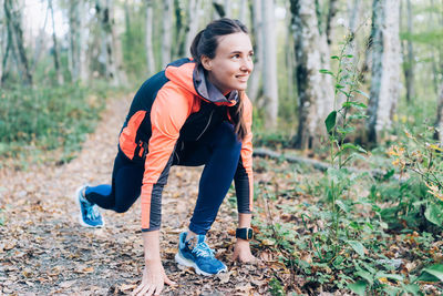 Portrait of young woman standing in forest