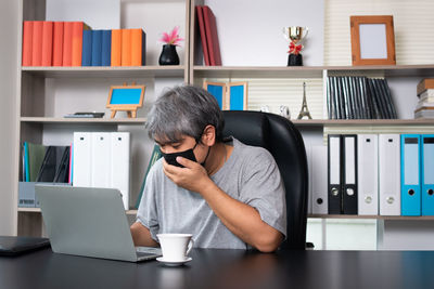 Full length of man using laptop on table