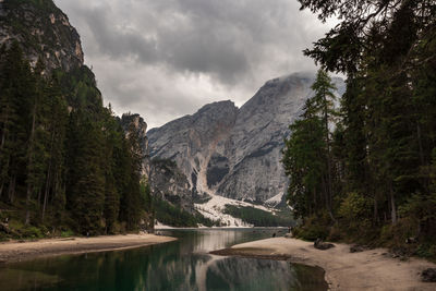 Scenic view of lake by mountains against sky