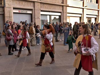 People standing on street against buildings in city