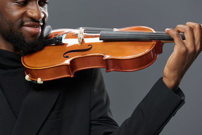 Midsection of man playing violin