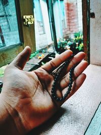 Close-up of hand holding glass window