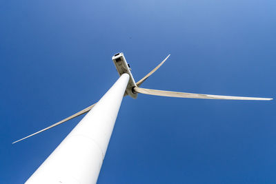 Low angle view of windmill against blue sky