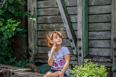 Little blonde girl posing in front of old train wagon