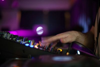 Dj adjusting knobs on sounder mixer