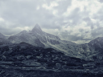 Scenic view of mountains against cloudy sky