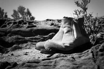 Close-up of shoes on beach