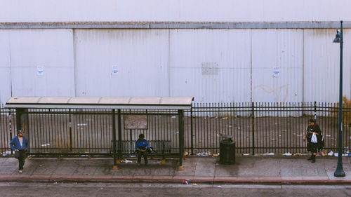 People on street against wall in city