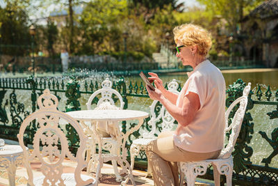 Mature attractive woman traveler sitting alone on the terrace of coffee shop