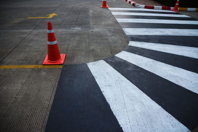 Traffic cones by zebra crossing on road in city