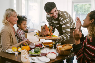 Man holding food by people on table