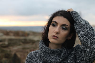 Portrait of beautiful woman against sky during winter