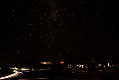 Illuminated city against sky at night