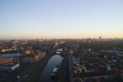 High angle view of river amidst buildings in city against clear sky