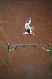 Playful girl enjoying on swing at playground