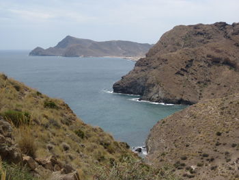 Scenic view of sea and mountains against sky