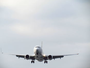 Low angle view of airplane flying against sky