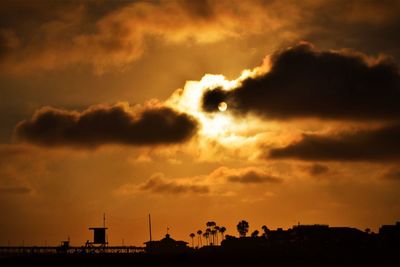 Low angle view of silhouette buildings against dramatic sky