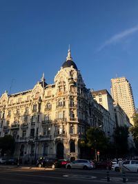 View of city buildings against blue sky