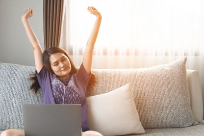 Young woman using mobile phone at home
