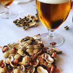 Close-up of beer with peanuts on table