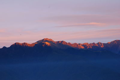 Scenic view of snowcapped mountains against sky during sunset