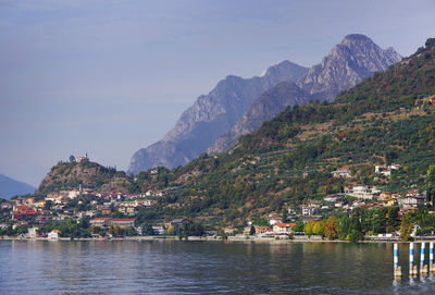 Town by river and mountains against sky