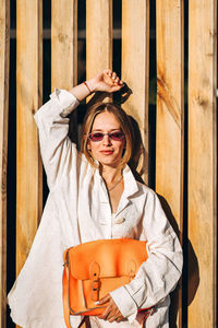 Portrait of young woman against planks