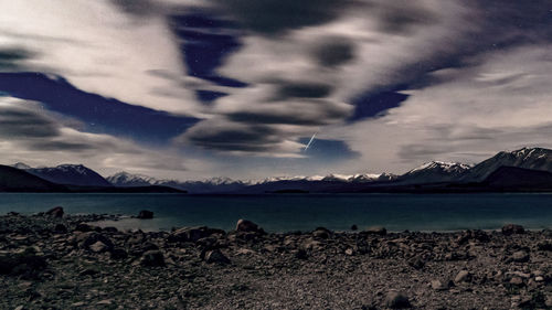 View of calm lake against cloudy sky
