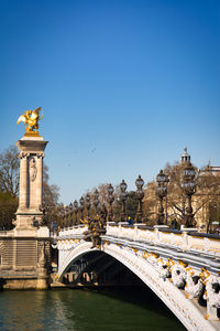 Statue of bridge against clear blue sky