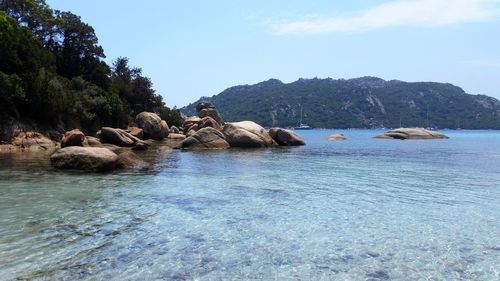 Rocks in sea against sky