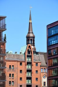 Low angle view of buildings against blue sky