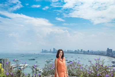 Portrait of woman standing against sea 