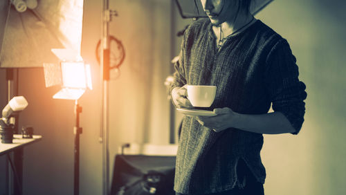 Man holding coffee cup at home