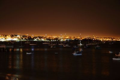 Illuminated city at waterfront at night