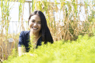 Portrait of smiling young woman lying on land