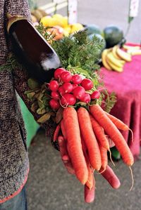 Close-up of hand holding vegetables for sale in market