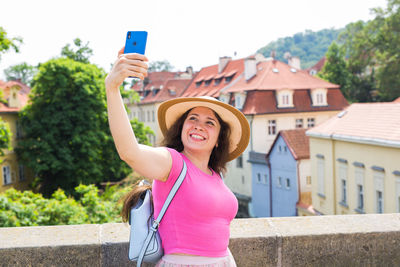 Portrait of woman photographing on mobile phone