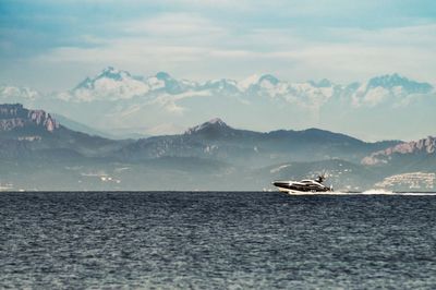 Scenic view of sea and mountains against sky