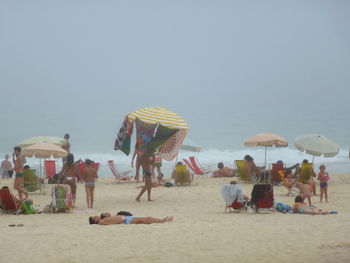 People at beach against sky